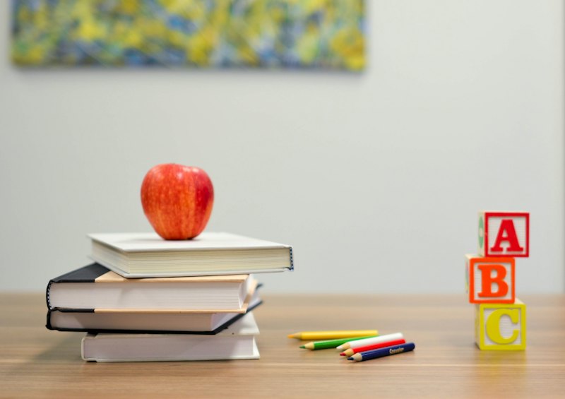 Books and an apple on a desk